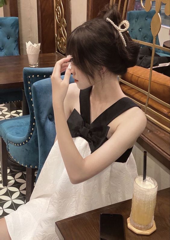 Ảnh gái xinh uống trà sữa che mặt chụp ảnh bên cạnh bó hoa