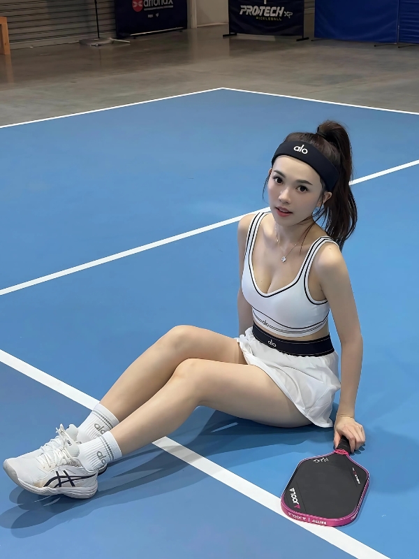 Ảnh gái chơi pickle ball ngồi bắt chéo chân