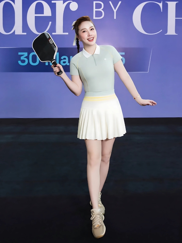 Ảnh gái chơi pickle ball cười tươi trước banner