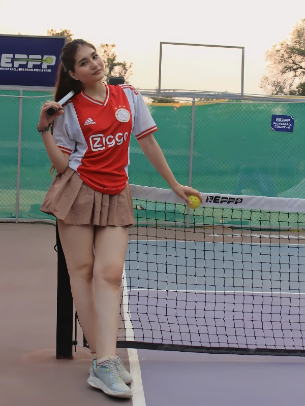 Ảnh gái chơi pickle ball mặc đồng phục đỏ
