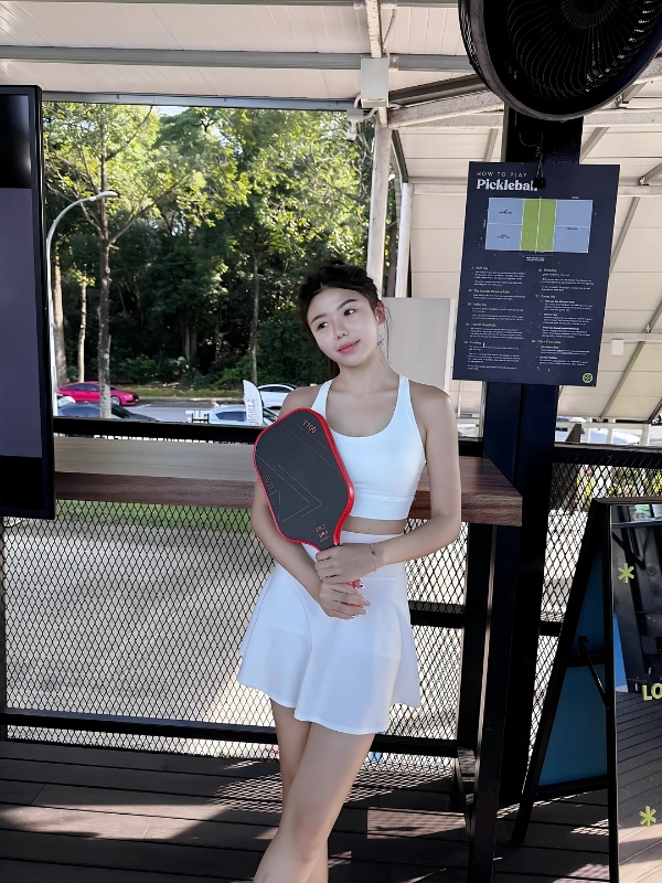 Ảnh gái chơi pickle ball tạo dáng cùng máy đo điểm