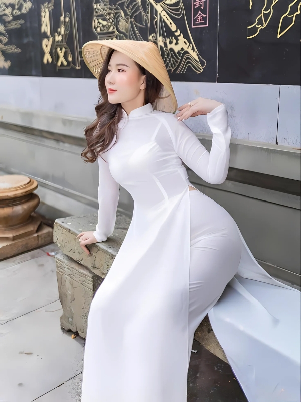 Tạo dáng bên tường trong áo dài trắng