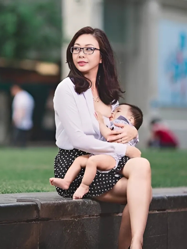 Mẹ xinh cho con bú trên ghế đá