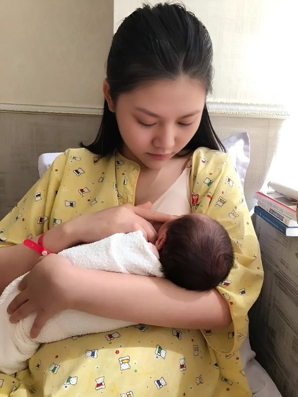 Gái xinh mặc váy vàng cho con bú