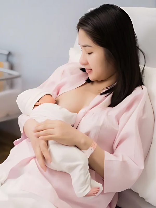 Gái xinh mặc áo hồng bế con bú