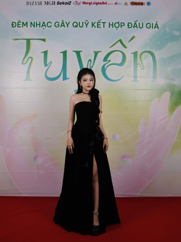 Bộ váy đen xẻ tà khoe đôi chân thon dài.