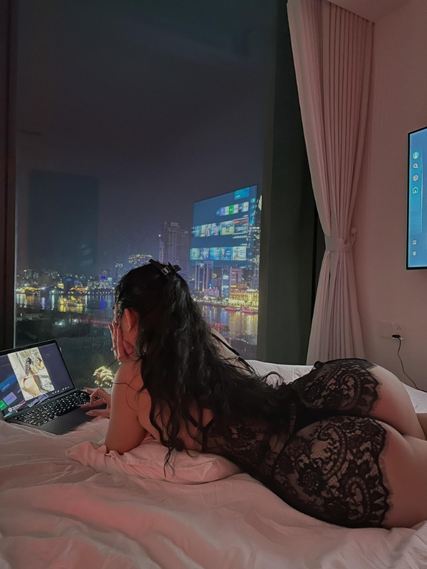 Tạo dáng quyến rũ bên cửa sổ với ánh đèn thành phố